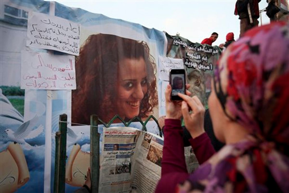 An anti-government protester takes a picture of a poster of Sally Zahran, age 23, who was killed in southern Egypt last month during clashes, in Tahrir Square, in Cairo, Egypt, Tuesday, Feb. 8, 2011. Faces of some of the hundreds killed in Egypt's two-week-old uprising are beginning to emerge from the fog of chaos. Details of the lives lost have started to appear in Egyptian newspapers, on websites and in huge posters put up in Cairo's Tahrir Square, the center of the revolt that erupted Jan. 25. The paper next to the photo reads in Arabic "Sally the martyr. She taught Egyptian people the meaning of manhood". (AP Photo/Tara Todras-Whitehill) (AP)