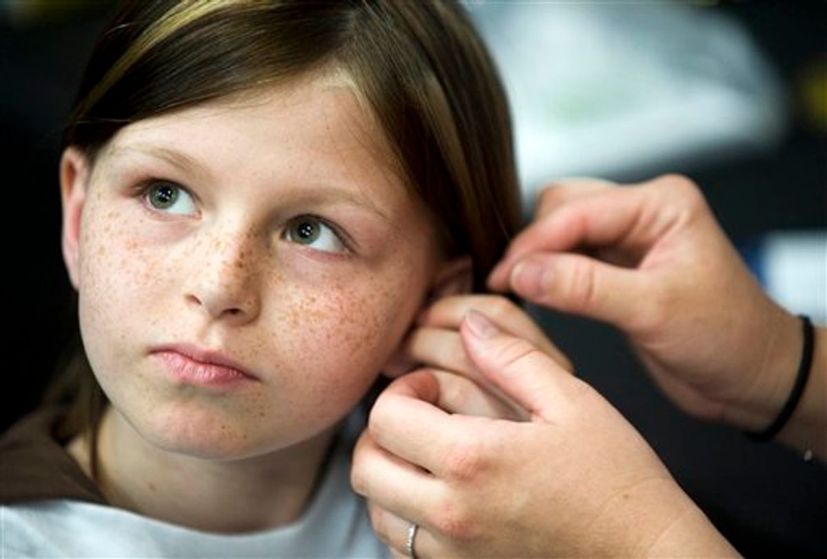 FILE -This May 2010 file photo shows Zahra Clare Baker, 10, getting a hearing aid during an event at Charlotte Motor Speedway in Hickory, N.C. Elisa Baker , stepmother of Zahra Clare Baker, was indicted Monday, Feb. 21, 2011 on a second-degree murder charge in Zahra Clare Baker's death. Elisa Baker had previously been charged with obstructing justice in the investigation of Zahra Baker's death. The 10-year-old was reported missing in October, and police later found her remains in different locations in western North Carolina. (AP Photo/The Independent Tribune, James Nix, File) (AP)