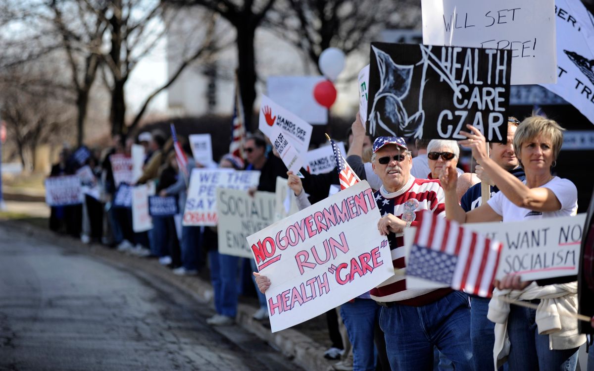 Protesters hold signs and yell at passing cars during a tea party protest against the proposed health care plan outside the office of Rep. Melissa Bean, D-Ill., in Schaumburg, Ill. on Tuesday, Mar. 16, 2010. (AP Photo/Paul Beaty) (Paul Beaty)