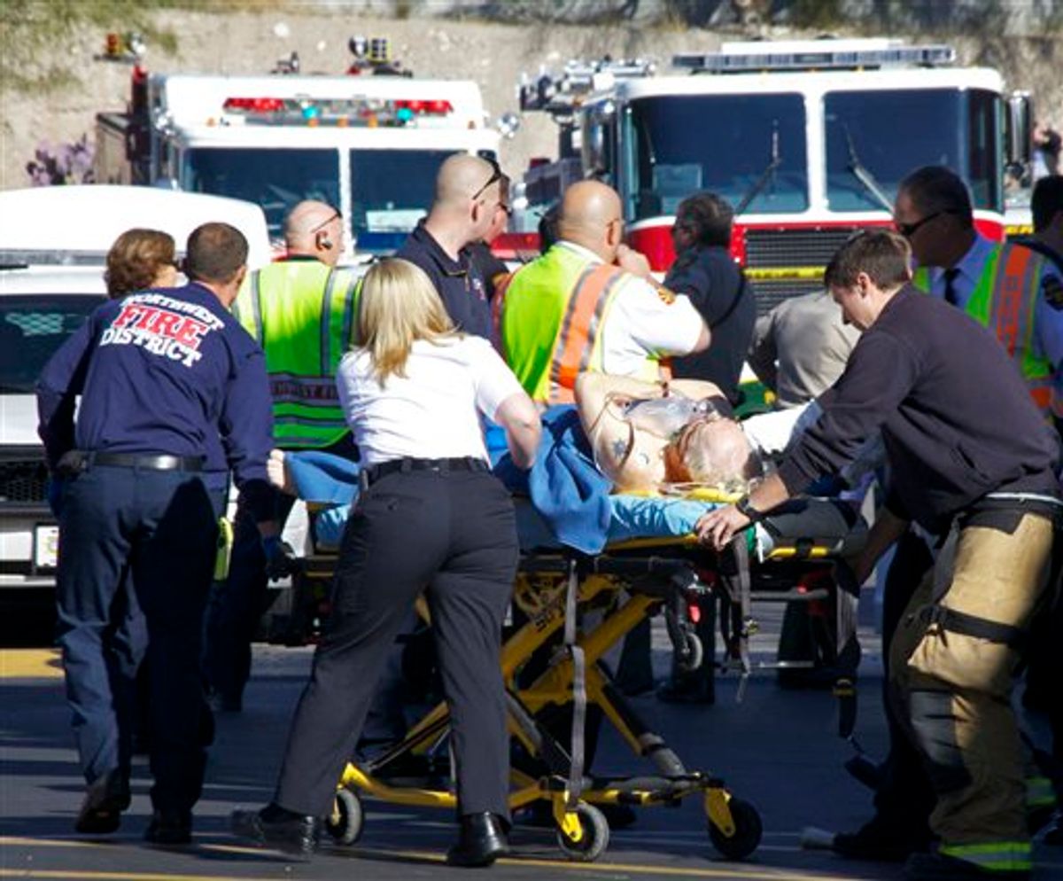 Emergency personnel attend to a shooting victim  outside a shopping center in Tucson, Ariz. on Saturday, Jan. 8, 2011 where U.S. Rep. Gabrielle Giffords, D-Ariz., and others were shot as the congresswoman was meeting with constituents.  (AP Photo/James Palka) (AP)