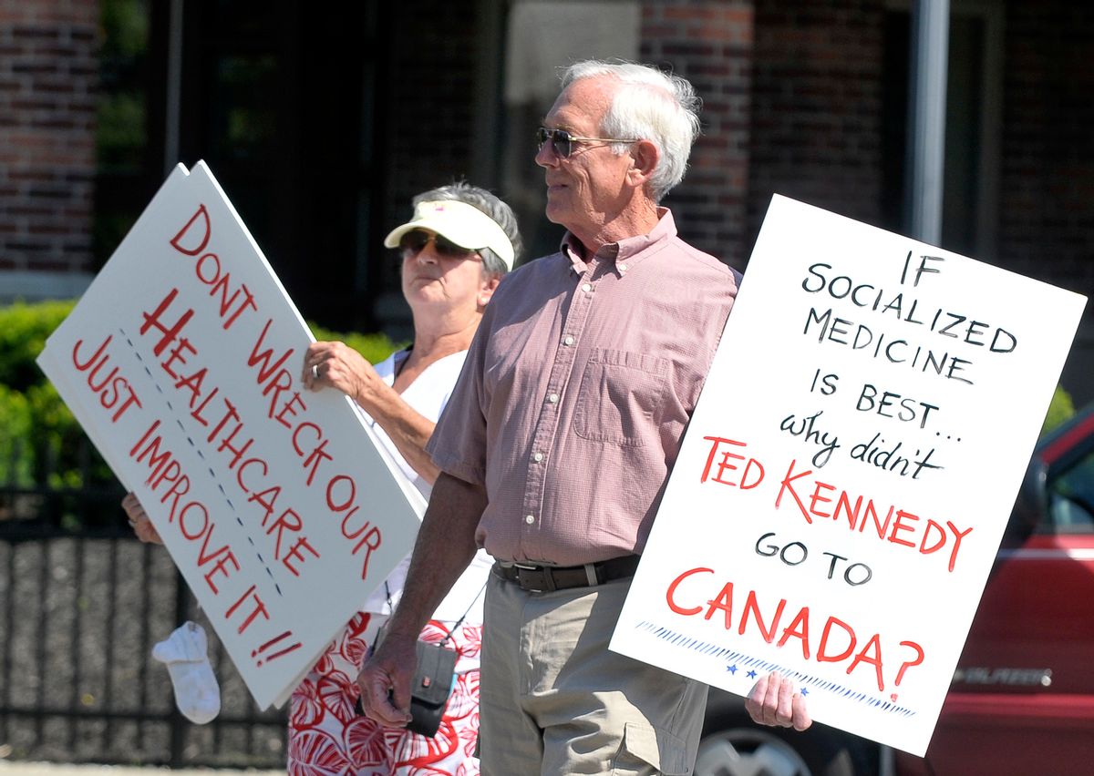 Elizabeth Smith ,left, and her husband Spence Smith hold protest signs during a rally protesting goverment managed health care in Saratoga Springs, N.Y., Thursday, August 6, 2009. (AP Photo/Hans Pennink) (Hans Pennink)