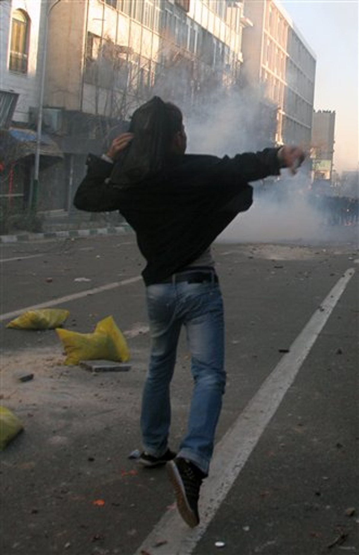 This photo, taken by an individual not employed by the Associated Press and obtained by the AP outside Iran shows an Iranian protestor throwing stone at ant-riot police officers, during an anti-government protest in Tehran, Iran, Monday, Feb. 14, 2011. Eyewitnesses report that sporadic clashes have erupted in central Tehran's Enghelab or Revolution square between security forces and opposition protesters. The demonstrators were chanting "death to the dictator," referring to the country's hardline president that the opposition believes was reelected through fraud in 2009. (AP Photo) EDITORS NOTE AS A RESULT OF AN OFFICIAL IRANIAN GOVERNMENT BAN ON FOREIGN MEDIA COVERING SOME EVENTS IN IRAN, THE AP WAS PREVENTED FROM INDEPENDENT ACCESS TO THIS EVENT (AP)