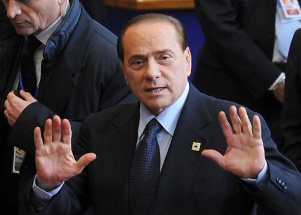 Italy's Prime Minister Silvio Berlusconi motions to the media as he leaves an EU summit in Brussels, Friday, Feb. 4, 2011. EU leaders meet for a one-day summit on Friday, with energy, the eurozone debt crisis and unrest in Egypt set to dominate the agenda. (AP Photo/Thierry Charlier) (AP)