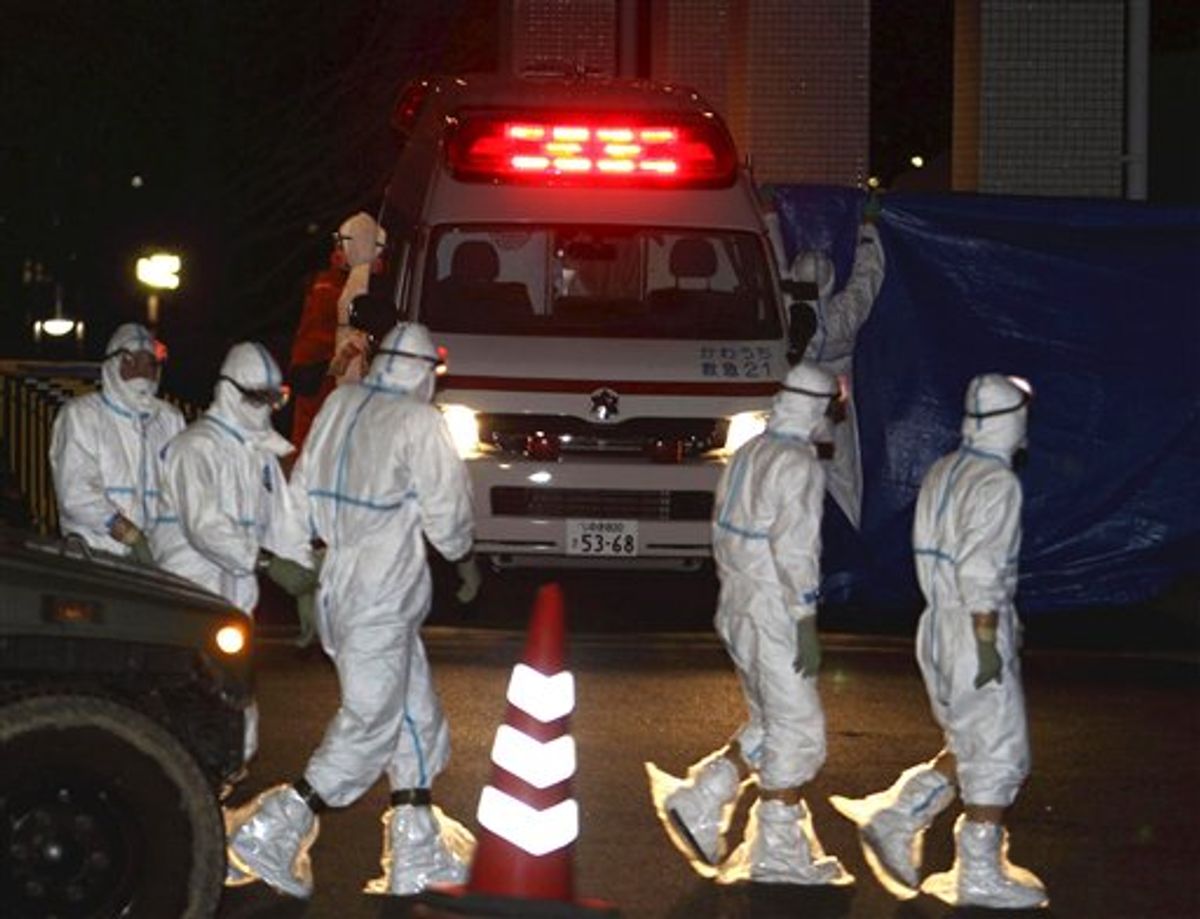 Medical workers in protective gear gather around an ambulance which arrived at a hospital in Fukushima City, Fukushima Prefecture, Japan, carrying two workers from the tsunami-damaged Fukushima Dai-ichi nuclear power plant after they stepped into contaminated water while laying electrical cables in one unit Thursday, March 24, 2011. (AP Photo/Yomiuri Shimbun, Jun Yasukawa) JAPAN OUT, MANDATORY CREDIT (AP)