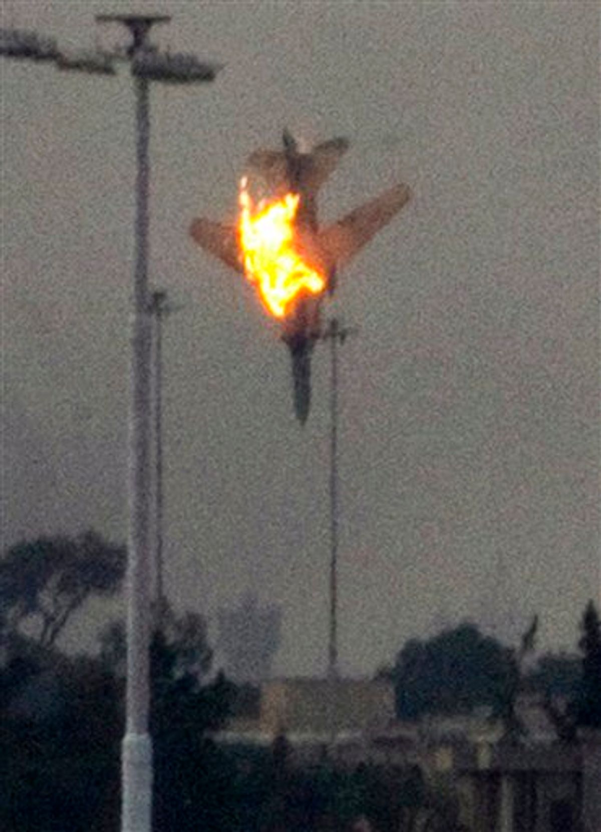 ALTERNATIVE CROP - A doomed warplane plummets towards earth after it was shot down by anti-Gadhafi forces over the outskirts of Benghazi, eastern Libya, Saturday, March 19, 2011.  An object, thought to be the pilot, was seen to eject from the cockpit shortly before impact.  Explosions shook the Libyan city of Benghazi early on Saturday while a fighter jet was heard flying overhead, and residents said the eastern rebel stronghold was under attack from  forces loyal to Libyan leader Moammar Gadhafi. (AP Photo/Anja Niedringhaus) (AP)
