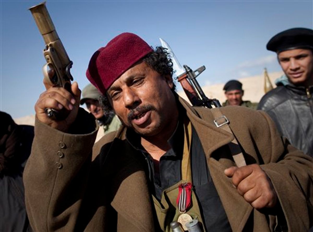 A Libyan rebel gestures before moving closer to the frontline after  Moammar Gadhafi's forces fired on them on the frontline of the outskirts of the city of Ajdabiya, south of Benghazi, eastern Libya, Tuesday, March 22, 2011. (AP Photo/Anja Niedringhaus) (AP)