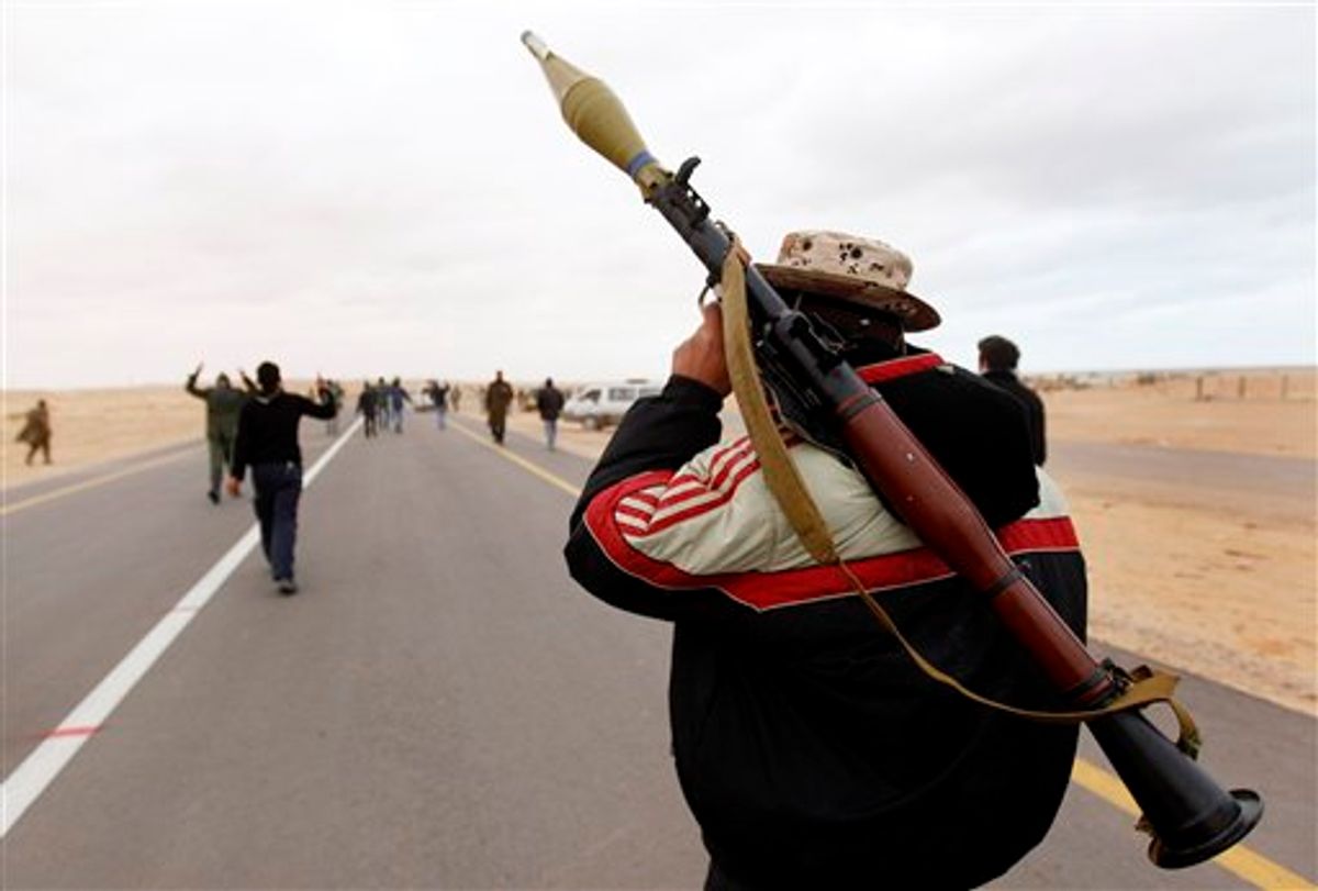An anti-Gadhafi rebel, carries his RPG as he walks forward with other rebels to fight in the front line during fighting against pro-Gadhafi fighters, near the town of Bin-Jawad, eastern Libya, Tuesday, March 8, 2011. Libyan warplanes launched at least three new airstrikes Tuesday near rebel positions in the oil port of Ras Lanouf, keeping up a counteroffensive to prevent the opposition from advancing toward leader Moammar Gadhafi's stronghold in the capital Tripoli. (AP Photo/Hussein Malla) (AP)