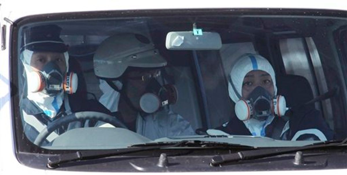Police officers wearing gas masks patrol in the area of the Fukushima power plant's Unit 1 in Okumamachi, Fukushima Prefecture (state), northern Japan, Saturday, March 12, 2011, amid fears that a part of the plant could meltdown after being hit by a powerful earthquake and tsunami Friday. (AP Photo/The Yomiuri Shimbun, Kaname Yoneyama)  JAPAN OUT, CREDIT MANDATORY (AP)
