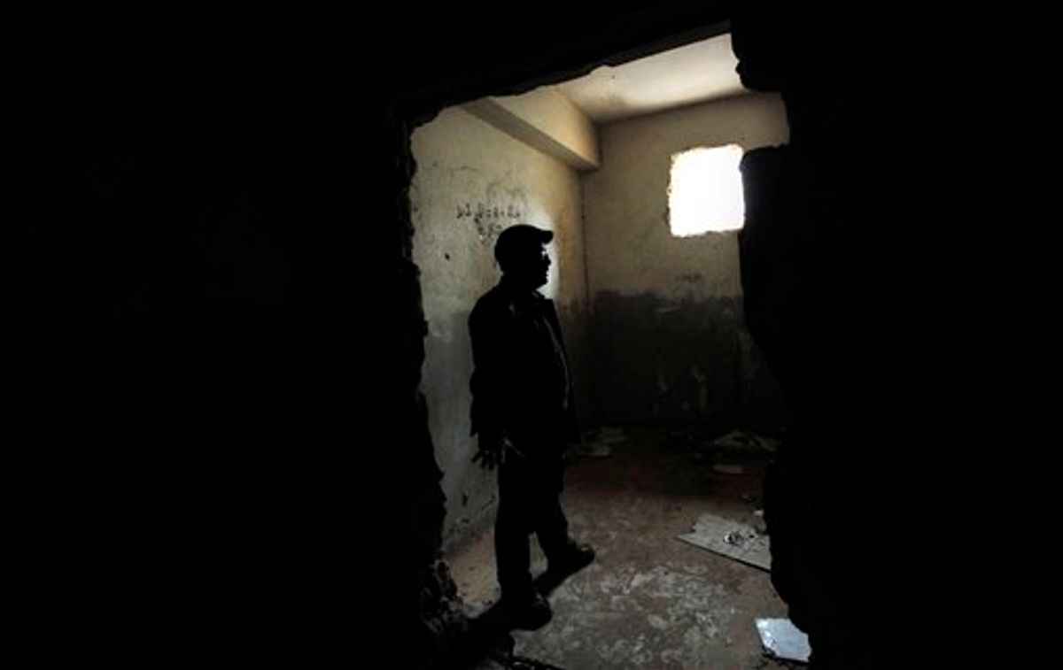 In this photo taken Tuesday, March 8, 2011, Libyan businessman Fadlallah Haroun, 45, who spent seven years in Moammar Gadhafi's prisons without being charged, stands in a cell at a stormed security base in the city of Benghazi, the Katiba building, where he spent 14 days before being transferred to Abu Selim prison in Tripoli, Libya. Now that eastern Libya has ripped itself free from Gadhafi's grip, residents there finally feel safe to talk about what life was like under the regime. The stories they tell are stamped with the terror, paranoia and sinking sense of desperation instilled in the people by Gadhafi since he took power in a 1969 coup. (AP Photo/Nasser Nasser)  (AP)