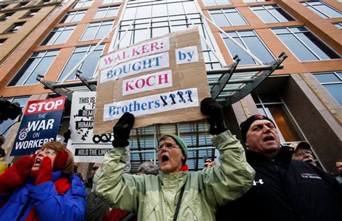 Jane Pederson, center, of Menomonie, Wis., protests in front of the offices of Koch Industries in Madison, Wis., Thursday, Feb. 24, 2011. Opponents to the governor's budget are in their tenth day of protests. (AP Photo/Andy Manis) (AP)