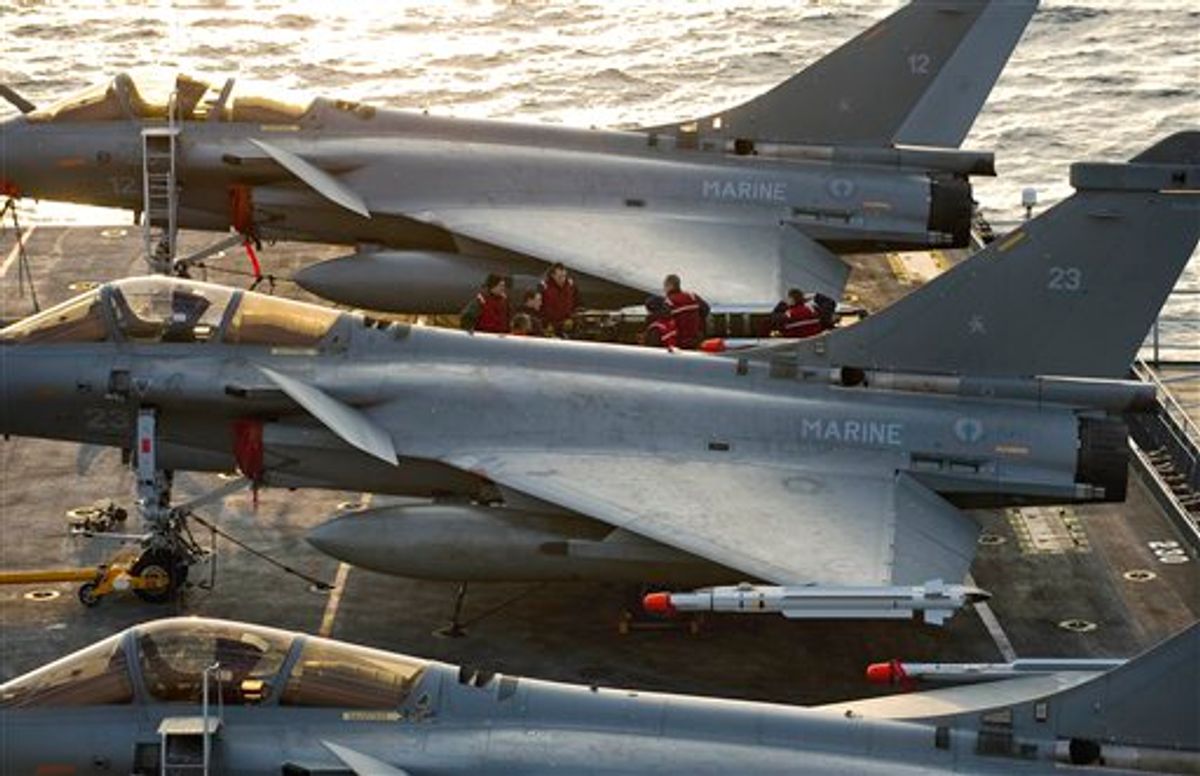 In this Wednesday March 23, 2011 photo provided by the French Army, French Navy Rafale jet fighters on the deck of Charles de Gaulle aircraft carrier in the Mediterranean sea. The international military operation against Libyan leader Moammar Gadhafi's forces may last days or weeks _ but not months, France's foreign minister said Thursday. Alain Juppe also said that he hopes the campaign in Libya serves as a warning to autocratic regimes elsewhere, including in Syria and Saudi Arabia.  (AP Photo/Raphael Martinez) NO SALES (AP)