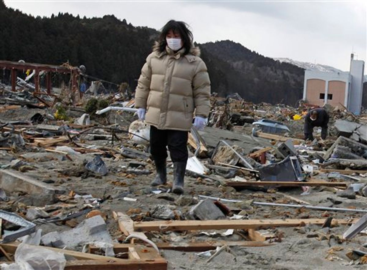 A woman searches for her missing husband through the earthquake and tsunami-hit town of Minamisanriku, Miyagi Prefecture,  Friday, March 18, 2011.  (AP Photo/Shuji Kajiyama) (AP)