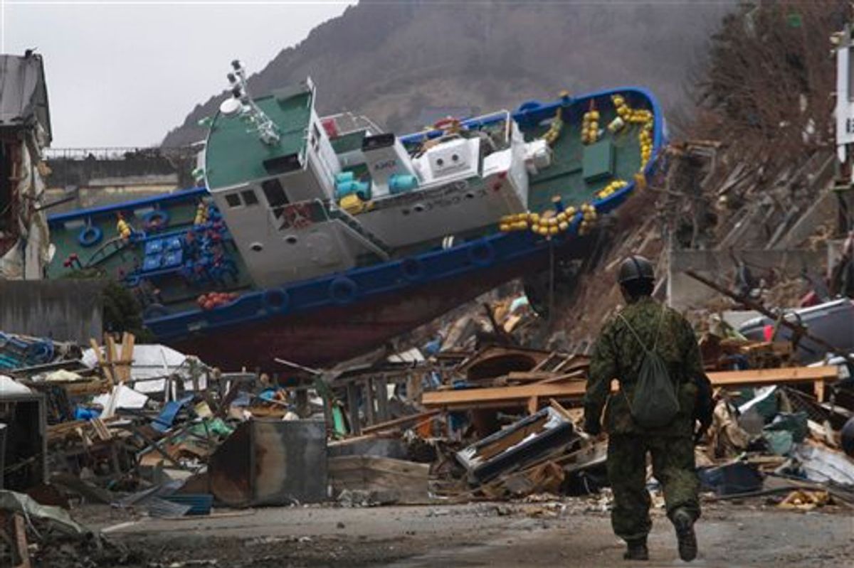 A Japanese soldier walks towards a ship which was blocking a road that his men were trying to clear in the earthquake and tsunami destroyed town of Onagawa, Miyagi Prefecture, northeastern Japan Sunday, March 20, 2011. (AP Photo/David Guttenfelder) (AP)