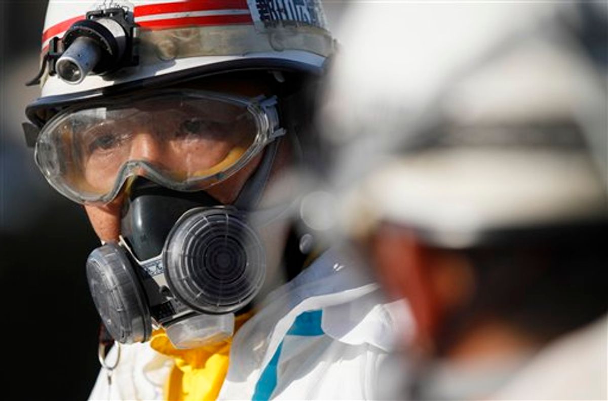 An official wears protective clothing while waiting to scan people for radiation an emergency center on Sunday, March 13, 2011, in Koriyama, northeastern Japan, two days after a giant quake and tsunami struck the country's northeastern coast.(AP Photo/Gregory Bull) (AP)