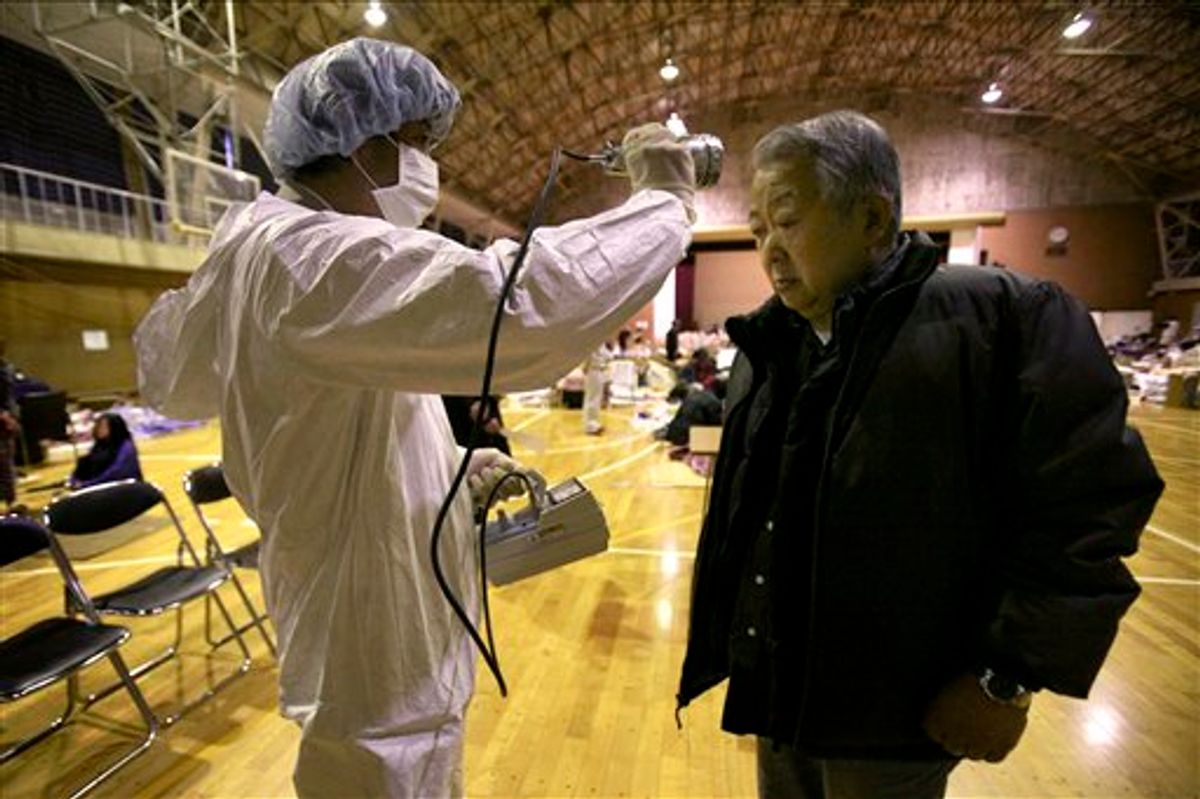 A man is screened for radiation exposure at a shelter after being evacuated from areas around the Fukushima nuclear facilities damaged by last week's major earthquake and following tsunami, Wednesday, March 16, 2011, in Fukushima city, Fukushima prefecture, Japan. (AP Photo/Wally Santana) (AP)