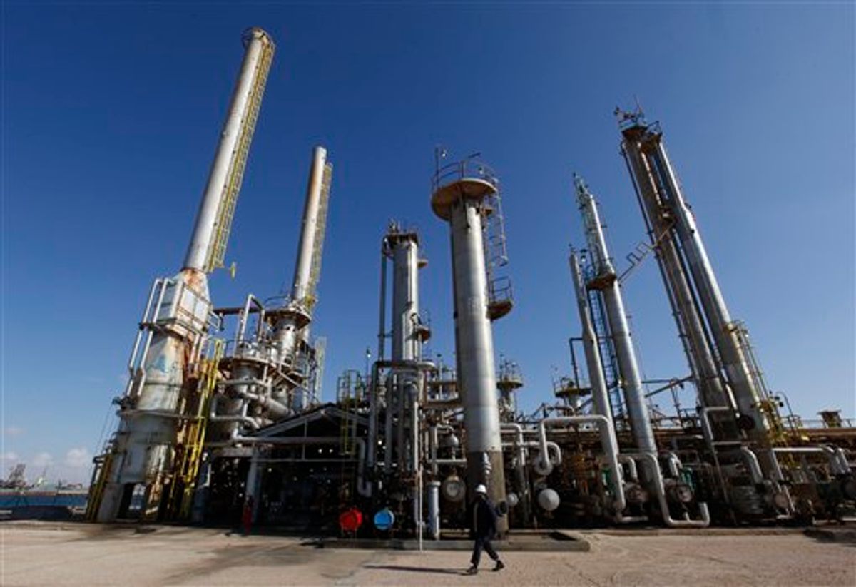 A Libyan oil worker walks in front of a refinery inside the Brega oil complex, in Brega east of Libya, on Saturday Feb. 26, 2011. Production at Brega has dropped by almost 90 percent amid the country's crisis because many employees have fled and few ships are coming to offload the product. (AP Photo/Hussein Malla) (AP)