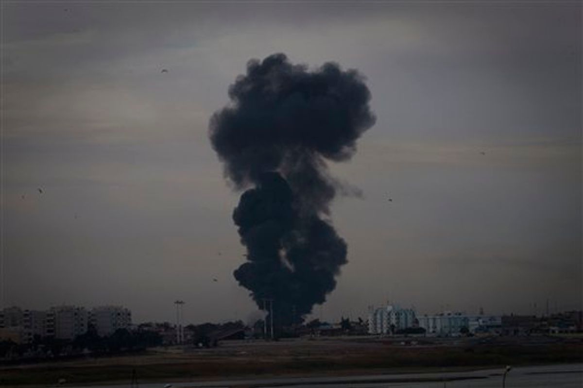 Smoke billows over the outskirts of Benghazi, eastern Libya, Saturday, March 19, 2011. Explosions shook the Libyan city of Benghazi early on Saturday while a fighter jet was heard flying overhead, and residents said the eastern rebel stronghold was under attack from Gadhafi's forces. (AP Photo/Anja Niedringhaus) (AP)