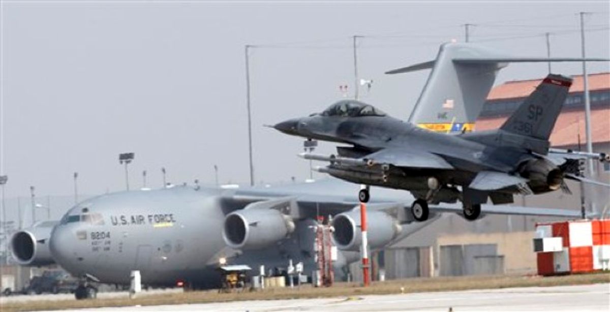 A 31st Fighter Wing United States Air Force F-16 jet fighter comes into land at the Aviano NATO airbase, in Aviano, Italy, Friday, March 25, 2011 with a Boeing C-17A Globemaster III of the 437th Airlift Wing in the background. (AP Photo/Luca Bruno) (AP)