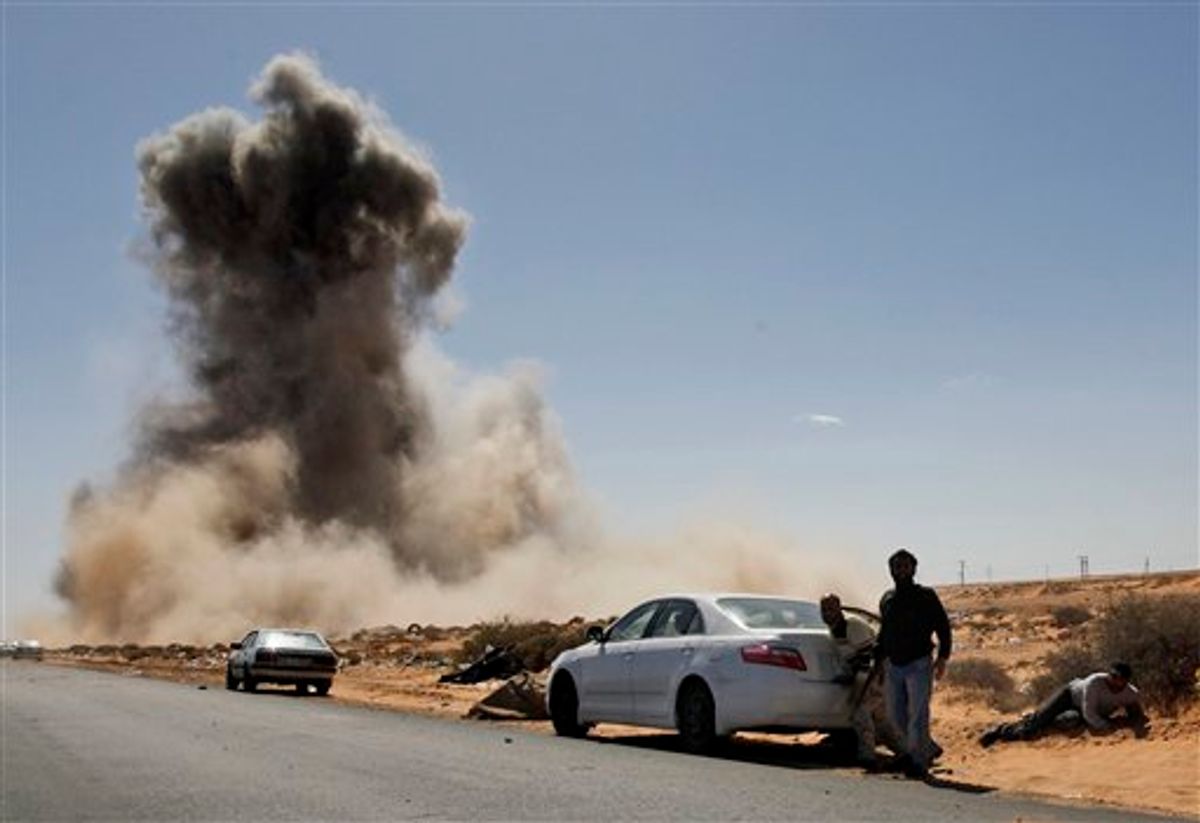 Smoke raises following an air strike by Libyan warplanes near a checkpoint near to the anti-Libyan Leader Moammar Gadhafi rebels checkpoint in the oil town of Ras Lanouf, eastern Libya, Monday, March 7, 2011.Forces loyal to Moammar Gadhafi have launched an airstrike against a rebel position in a key oil port. There were no casualties in the Monday morning attack in Ras Lanouf.Libyan rebels say they are regrouping after forces loyal to Gadhafi pounded opposition fighters with helicopter gunships, artillery and rockets on Sunday to stop the rebels' rapid advance toward the capital. (AP Photo/Hussein Malla) (AP)