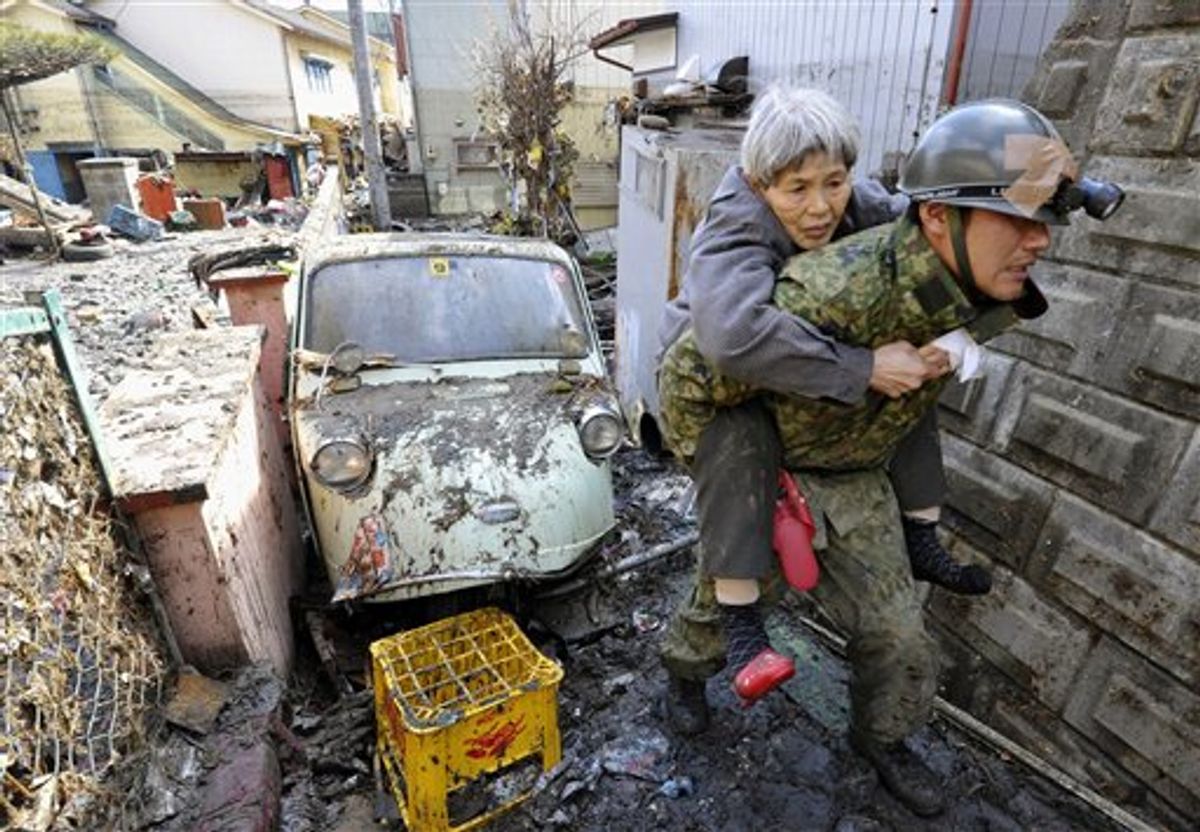 A man and woman seek information about the safety of relatives at an evacuation center at Rikuzentakada, northeastern Japan, on Saturday March 12, 2011, one day after a giant quake and tsunami struck the country's northeastern coast. (AP Photo/Kyodo News)  MANDATORY CREDIT, NO LICENSING ALLOWED IN CHINA, HONG  KONG, JAPAN, SOUTH KOREA AND FRANCE (AP)
