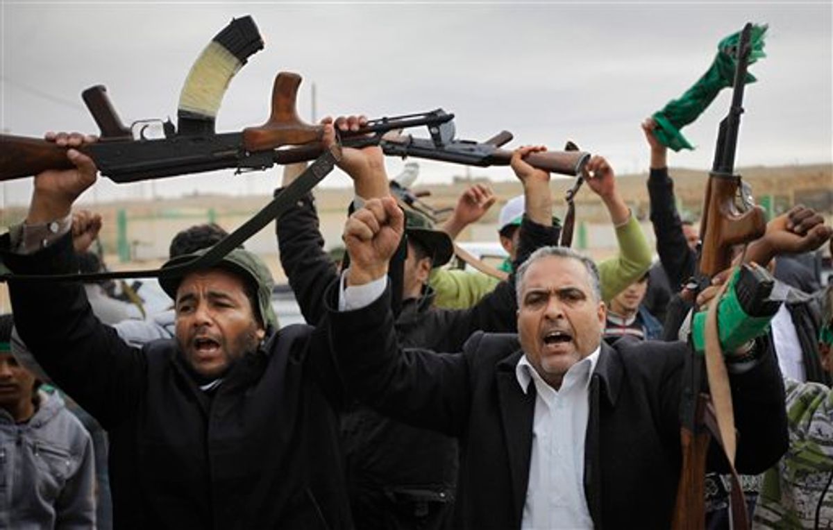 Pro-Gadhafi fighters raise their weapons as they are pictured during a government-organized visit for foreign media in Bin Jawwad, 350 miles (560 kilometers) southeast of the capital Tripoli, in Libya Saturday, March 12, 2011. The world moved a step closer to a decision on imposing a no-fly zone over Libya but Moammar Gadhafi was swiftly advancing Saturday on the poorly equipped and loosely organized rebels who have seized much of the country. (AP Photo/Ben Curtis) (AP)