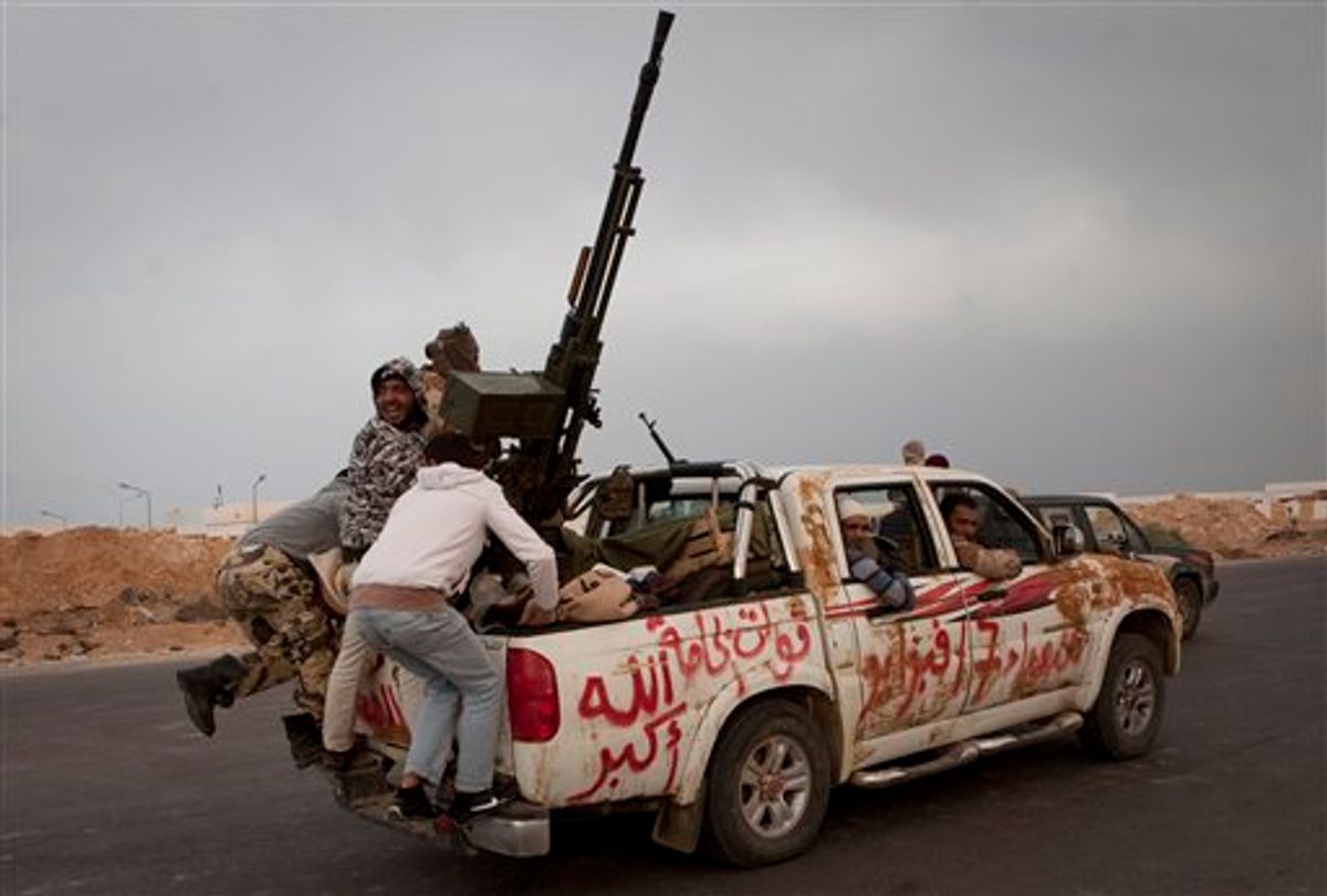 Libyan rebels jump onto the back of their vehicle as they leave Ras Lanouf, 250 km east of Sirte, central Libya, Tuesday, March 29, 2011. Gadhafi's forces drove the rebels out of Bin Jawwad, a hamlet east of Sirte, on Tuesday. Cars and trucks of the retreating rebels filled both lanes of the highway east to the oil port of Ras Lanouf.  (AP Photo/Anja Niedringhaus) (AP)
