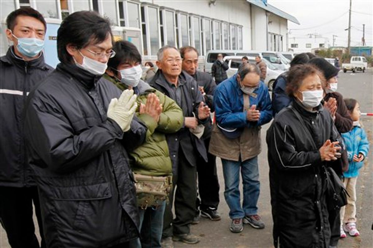 Residents pay their last respects to a victim as a van carrying the coffin leaves a temporary morgue at a bowling alley in Natori, Miyagi Prefecture Monday, March 21, 2011 as the death toll continues to rise following the March 11 earthquake and tsunami that devastated the northeast coast of Japan.  (AP Photo/Mark Baker)  (AP)