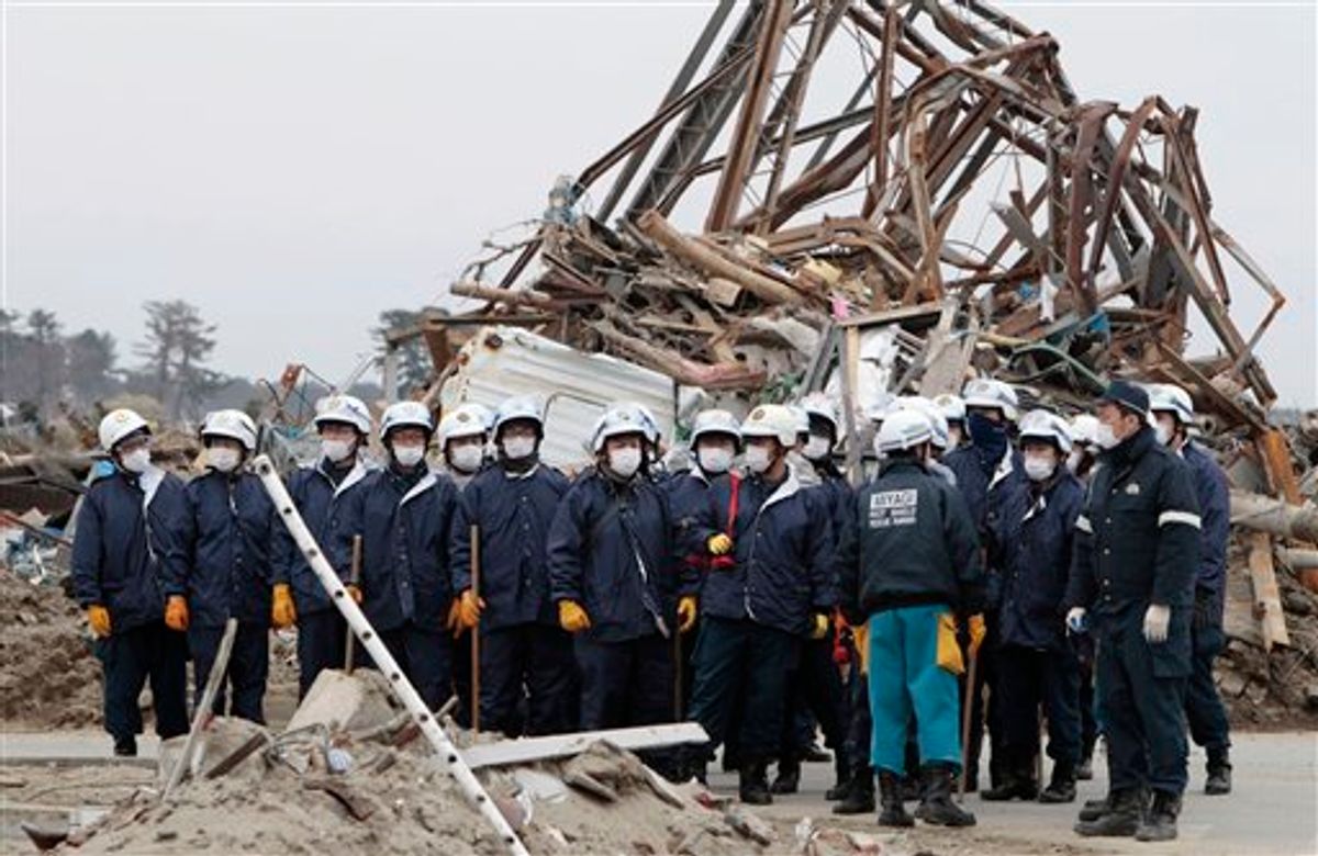 Japanese rescue workers prepare to sift through debris during a search in Natori, Miyagi Prefecture, Monday, March 21, 2011 following the March 11 earthquake and tsunami that devastated the northeast coast of Japan. (AP Photo/Mark Baker) (AP)