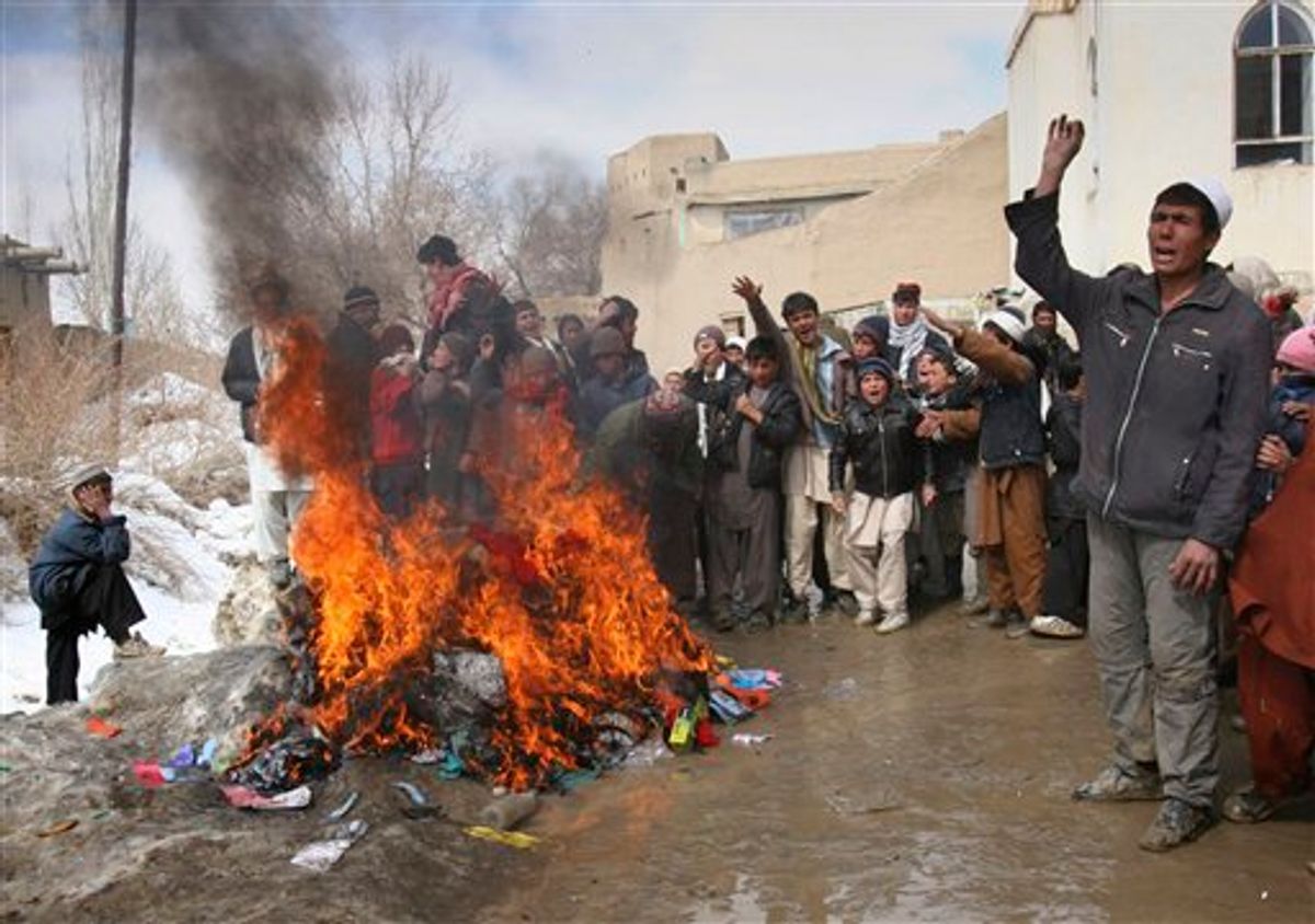 Afghans shout anti US slogans as they burning blankets, clothing and other items, which were distributed by coalition troops in Ghazni west of of Kabul, Afghanistan on Tuesday, March. 1, 2011. Residents in Ghazni burned blankets, clothing and other items that they said coalition troops had distributed in the city on Monday. (AP Photo/Rahmatullah Naikzad) (AP)