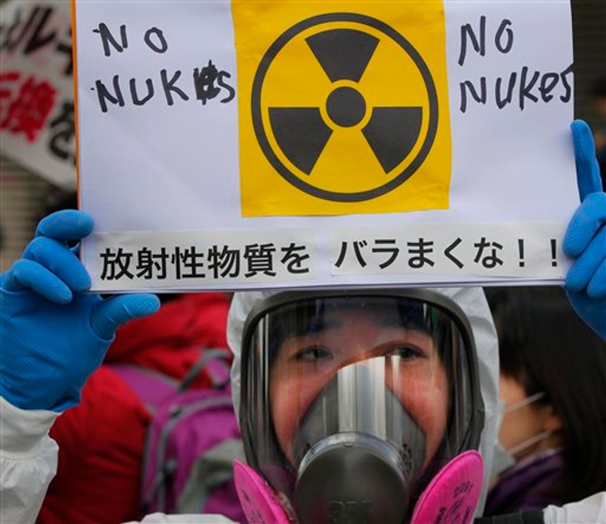 A protester in protective mask holds a placard during an anti nuclear rally in Tokyo, Sunday, March 27, 2011. Leaked water in Unit 2 of the Fukushima Dai-ichi plant measured 10 million times higher than usual radioactivity levels when the reactor is operating normally, Tokyo Electric Power Co. spokesman Takashi Kurita told reporters in Tokyo. The placard has a message that reads "Don't spread radioactive substance." (AP Photo/Itsuo Inouye) (AP)