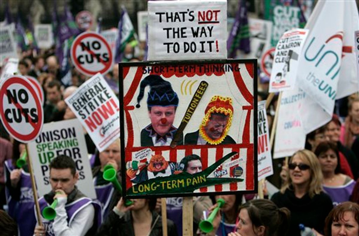Demonstrators protest against the coalition government spending cuts as they march in London, Saturday, March 26, 2011.   Some tens of thousands of mostly peaceful demonstrators streamed into central London on Saturday to march against government budget cuts, with a small breakaway group of demonstrators smashing its way into a bank, breaking windows and spray painting logos on the walls, as police struggle to contain the situation. (AP Photo/Akira Suemori) (AP)