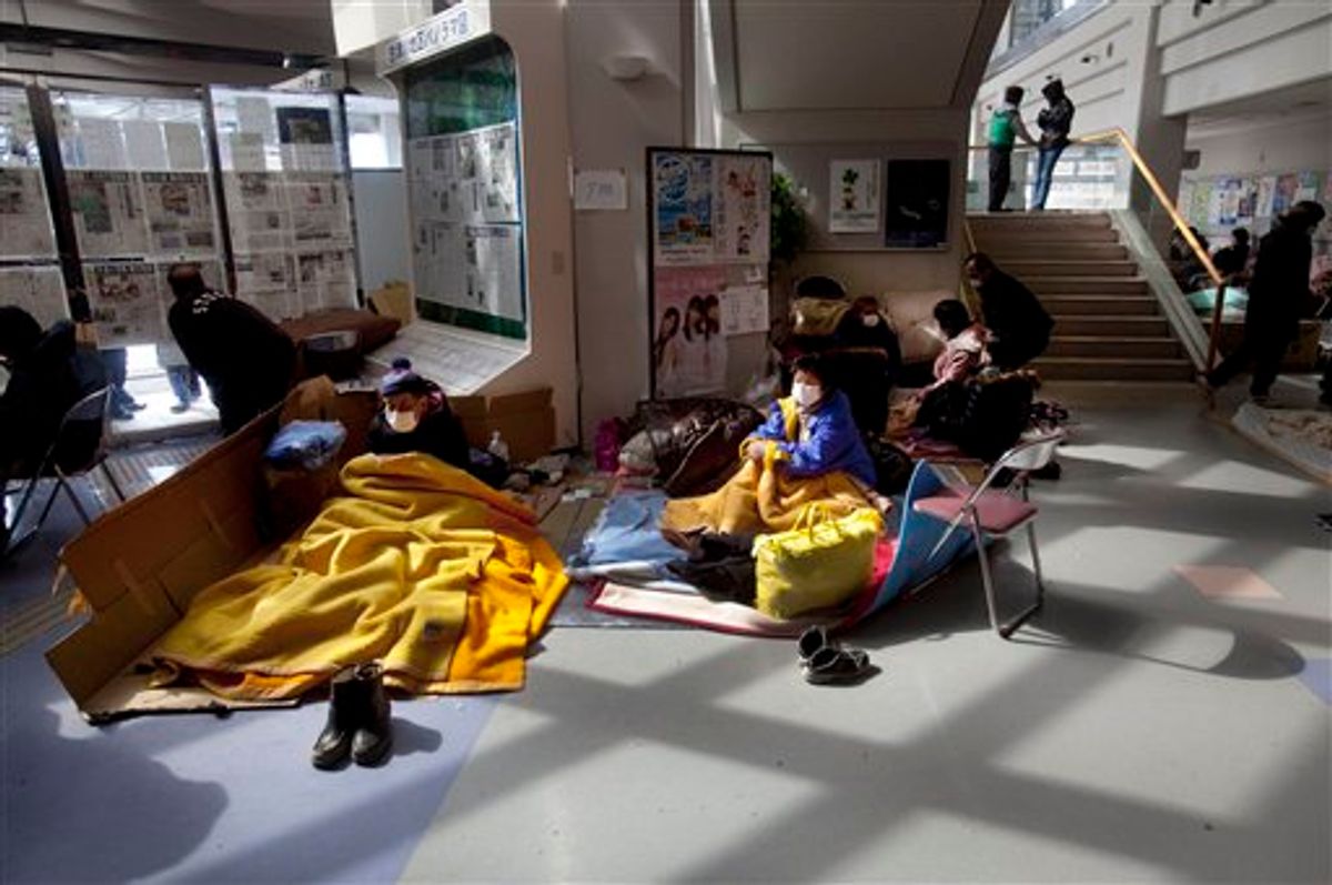 Japanese refugees sit inside a community center made into a shelter in the earthquake and tsunami-hit town of Minamisanriku, Friday, March 18, 2011.  (AP Photo/David Guttenfelder) (AP)