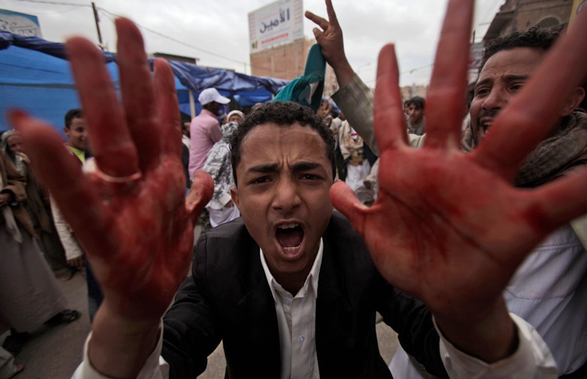 An anti-government protestor shouts with blood on his hands during clashes in Sanaa, Yemen, Friday, March 18, 2011.