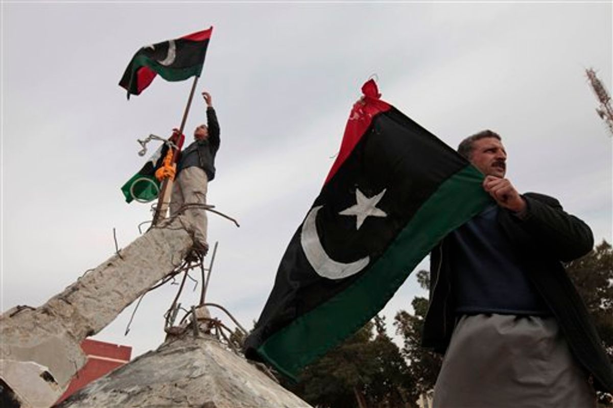 Libyans wave Libyan monarchist-era flags on a monument in the southwestern town of Nalut, Libya,  Monday, Feb. 28, 2011. The town is currently in control of the Libyan anti-government forces. (AP Photo/Lefteris Pitarakis) (AP)