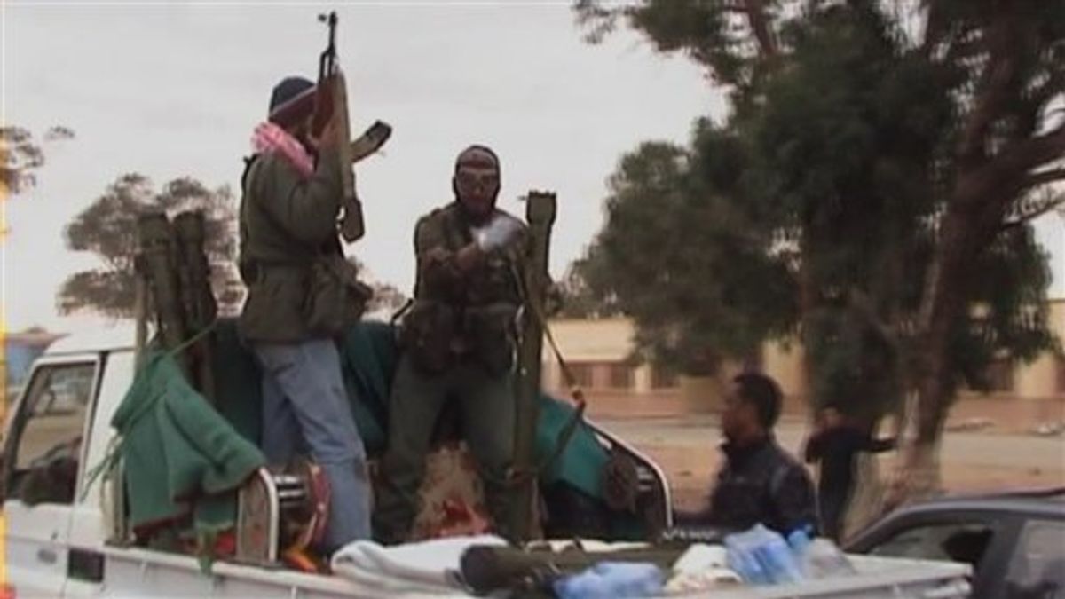 This image taken from video shows rebels on the back of a vehicle in the area of Benina, a civilian and military airport, outside Benghazi in eastern Libya Thursday March 17, 2011. Libyan rebels shot down at least two bomber planes that attacked the airport in their main stronghold of Benghazi Thursday, according to residents who witnessed the rare success in the struggle against Moammar Gadhafi's superior air power.  (AP Photo/APTN) (AP)
