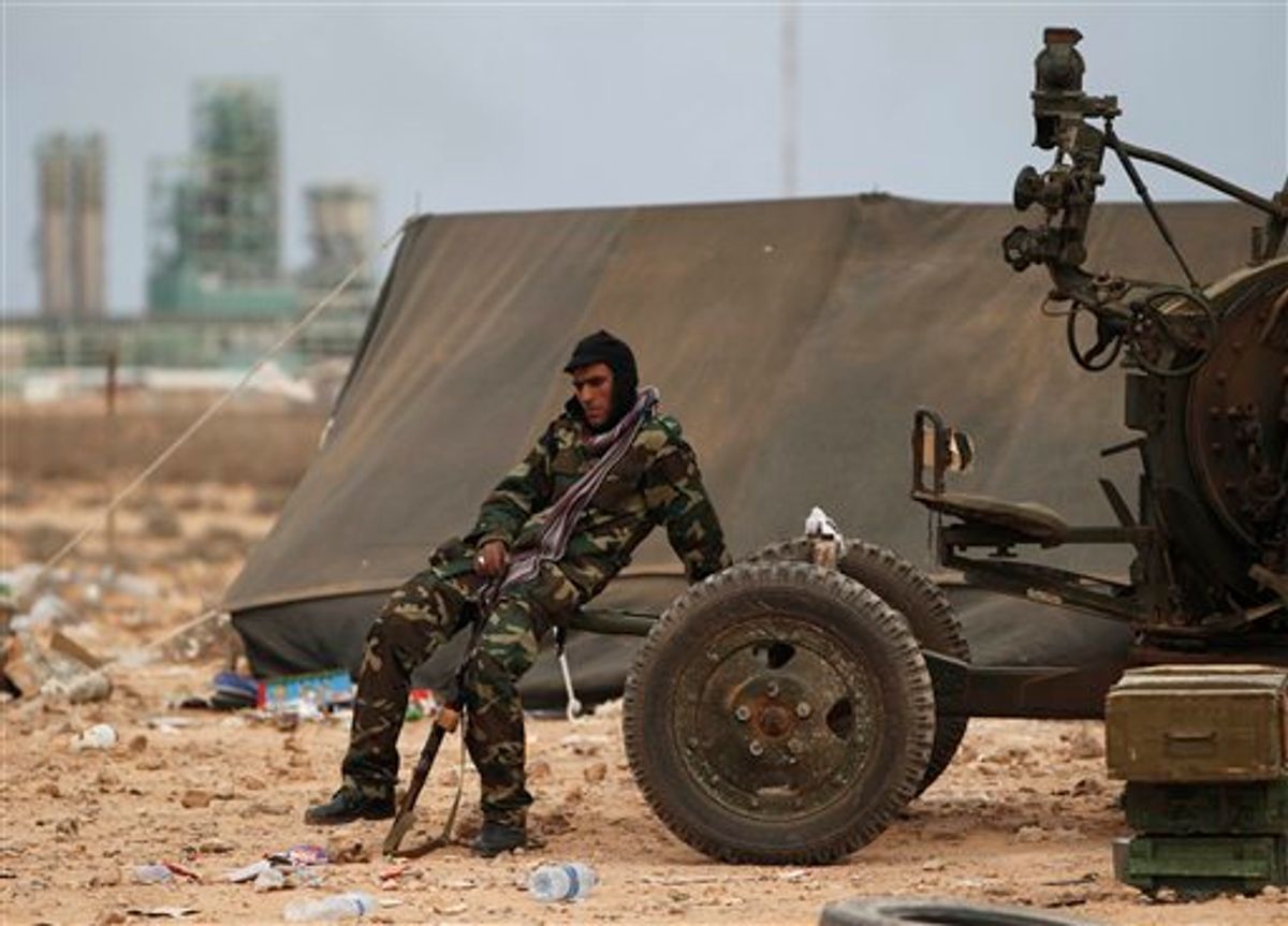 A Libyan volunteer sits near a weapon on the outskirts of the eastern town of Ras Lanouf, Libya, Thursday, March 10, 2011. Government forces drove hundreds of rebels from a strategic oil port with a withering rain of rockets and tank shells on Thursday, significantly expanding Moammar Gadhafi's control of Libya as Western nations struggled to find a way to stop him. (AP Photo/Tara Todras-Whitehill) (AP)