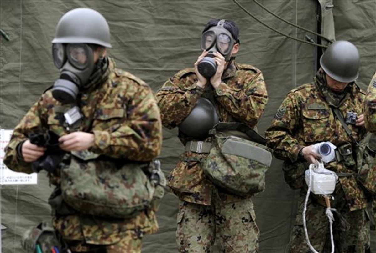 Japan Ground Self-Defense Force soldiers, mobilized to wash away radioactive material emitted from a nuclear power plant damaged by Friday's earthquake, put on protective gear on their arrival in Nihonmatsu, Fukushima Prefecture, Japan, Tuesday, March 15, 2011. (AP Photo/Kyodo News) JAPAN OUT, MANDATORY CREDIT, NO LICENSING IN CHINA, HONG KONG, JAPAN, SOUTH KOREA AND FRANCE (AP)