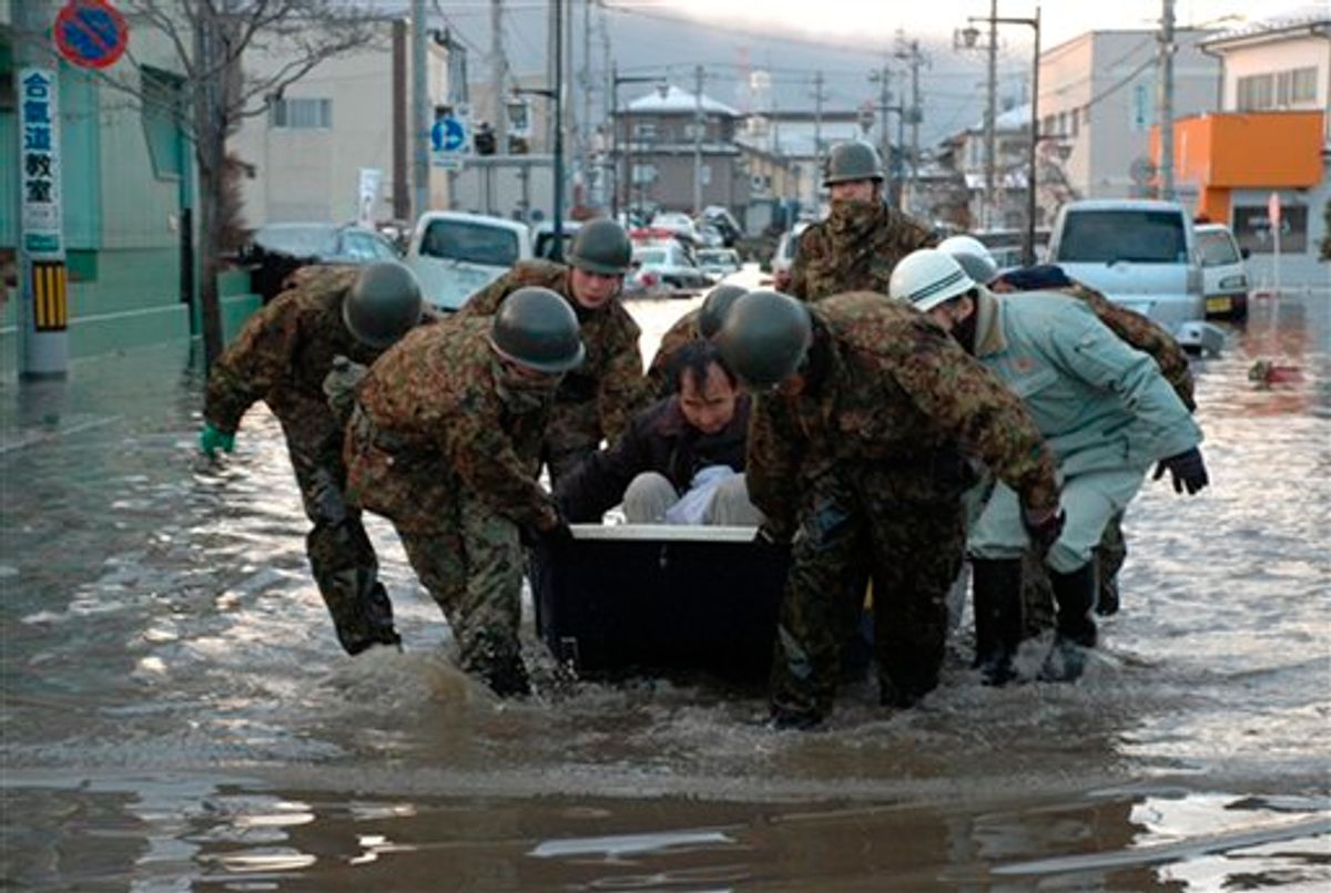 In this Saturday March 12, 2011, photo released by the Japan Defense Ministry, Japanese troopers escort a local resident as they help the evacuation of stranded people at Tagajo, northeastern Japan, after Friday's earthquake and the ensuing tsunami. (AP Photo/Japan Defense Ministry) EDITORIAL USE ONLY (AP)