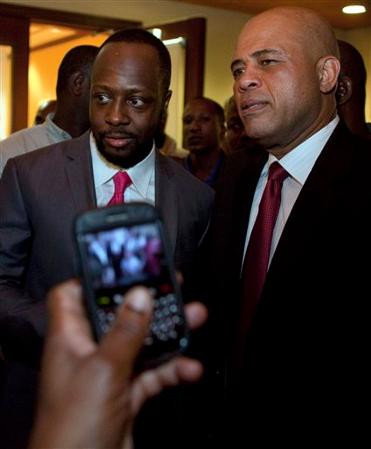 A person takes a photo with a mobile phone of Haiti's presidential candidate Michel Martelly, right, and Haitian-born singer Wyclef Jean after a press conference in which Jean announced his support on Martelly's run for the presidency in Port-au-Prince, Haiti, Wednesday, Feb. 16, 2011. (AP Photo/Ramon Espinosa) (AP)