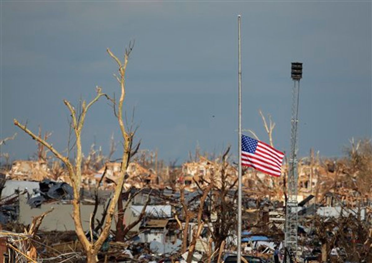 A flag files at half staff over devastated Joplin High School next to a portable tornado siren in Joplin, Mo. Thursday, May 26, 2011.  An EF-5 tornado tore through much of the city Sunday, damaging a hospital and hundreds of homes and businesses and killing at least 125 people. (AP Photo/Charlie Riedel) (AP)