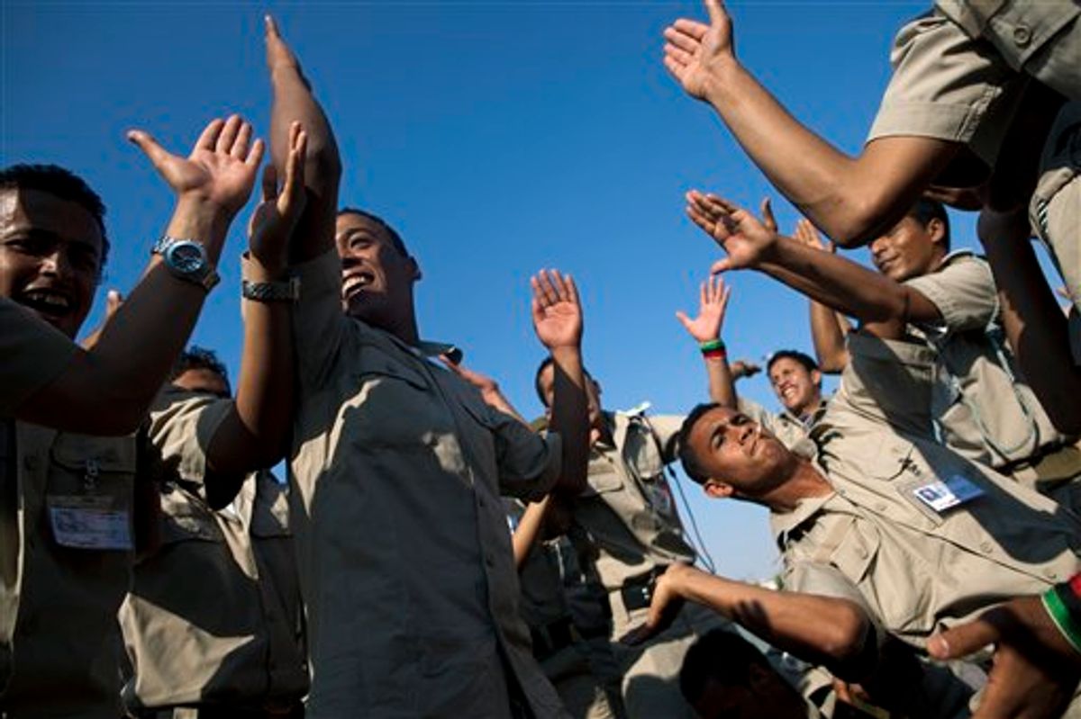 New cadets for the Libyan rebel army dance and chant anti Moammar Gadhafi  slogans before the ceremony graduation in Benghazi, Libya, Sunday, May 29, 2011.   (AP Photo/Rodrigo Abd) (AP)