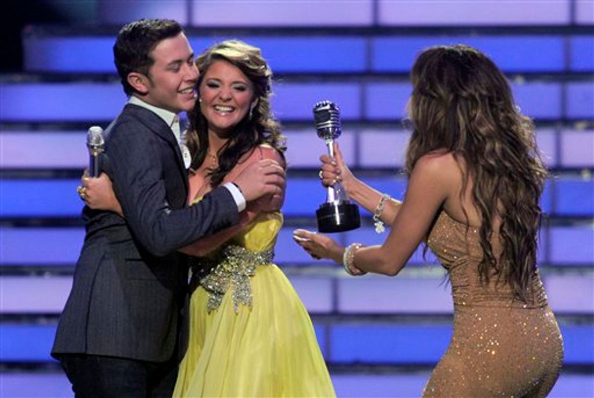 Winner Scotty McCreery, left, hugs finalist Lauren Alaina as Jennifer Lopez hand him his trophy at the "American Idol" finale on Wednesday, May 25, 2011, in Los Angeles. (AP Photo/Chris Pizzello)  (AP)