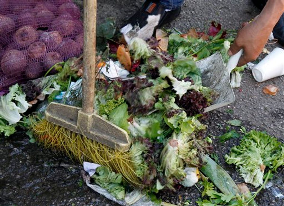 A man sweeps discarded salad vegetables from the floor at a food market in Vienna, Austria, on Monday May 30, 2011.  Vegetables from Spain are suspected of carrying the dangerous E.coli bacteria, which is suspected of killing some people in Germany and has caused many hundreds of people to become ill across Europe.  Austria has moved to ban the sale of cucumbers, tomatoes and eggplants that originated from Spain, although Spanish authorities said there is no proof that they are the source of the outbreak.(AP Photo/Ronald Zak) (AP)