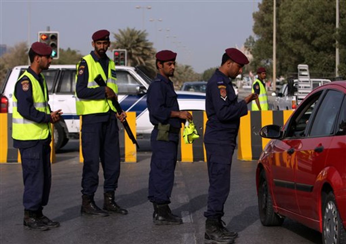 In this photo taken during a visit organized by Bahrain's Interior Ministry Bahrain police check a driver's identification at a checkpoint  in the capital of Manama, Bahrain  Monday, March 28, 2011. (AP Photo/Hasan Jamali) (AP)