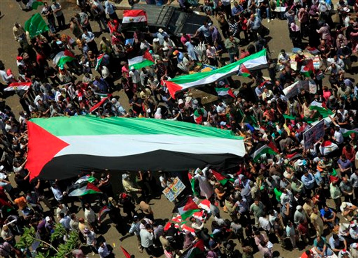 Egyptians carry a giant Palestinian flag during a protest against Israel's closure of Gaza as they march at Tahrir Square, the focal point of Egyptian uprising, in Cairo, Egypt Friday, May 13, 2011. (AP Photo/Amr Nabil) (AP)