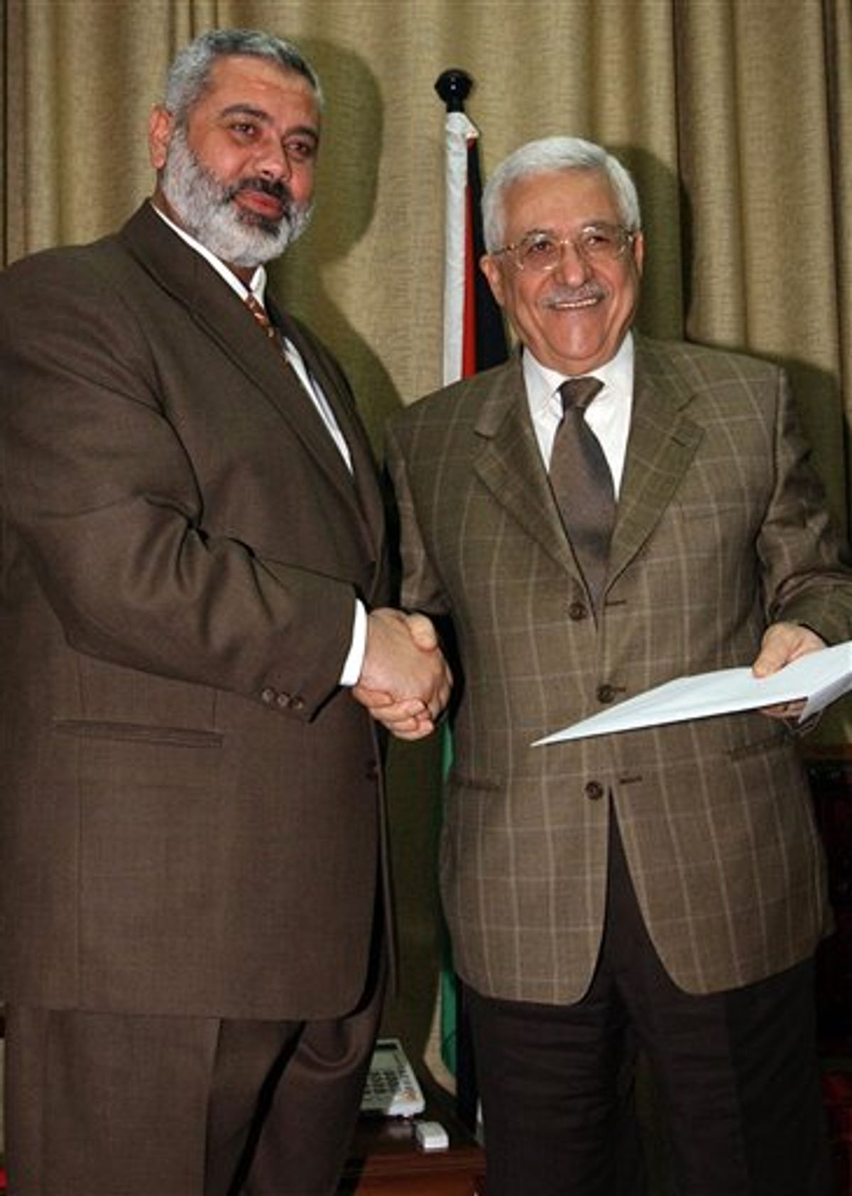 FILE - In this Sunday, March 19, 2006 file photo made available by the Palestinian Authority, the Palestinian Authority President Mahmoud Abbas, right, holds a file with the proposal for a new Palestinian Cabinet as he shakes hands with Palestinian Prime Minister Ismail Haniyeh, from the Islamic group Hamas, in Gaza City. Hamas officials said Tuesday, May 3, 2011, that the Islamic militant group would honor an unofficial truce with Israel after forming a new government with Palestinian rivals from the West Bank. (AP Photo/Abdel Alahim Abu Askar/Palestinian Authority, File)  (AP)