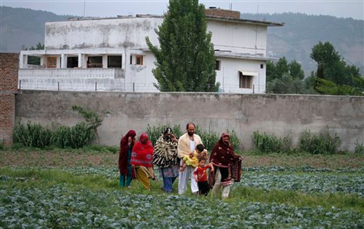 Pakistani family members leave the area after viewing the walled compound of a house, seen in background, where al-Qaida leader Osama bin Laden was caught and killed in Abbottabad, Pakistan, on Thursday,  May 5, 2011.  The residents of Abbottabad, Pakistan, seem to be confused and suspicious about the killing of Osama bin Laden by a U.S. military force, which took place in their midst before dawn on Monday. (AP Photo/Anjum Naveed) (AP)
