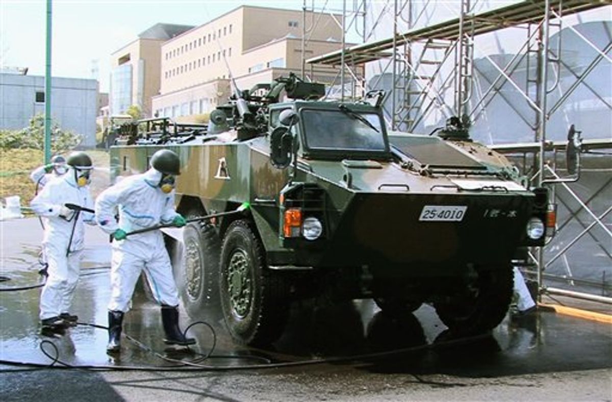 In this April 12, 2011 photo released by the Japan Defense Agency via Kyodo News, Japanese soldiers wash an armored vehicle to remove potential radiation contamination at J-Village, a soccer training complex now serving as an operation base for those battling Japan's worst nuclear disaster, northeastern Japan. The sports complex is about about 20 kilometers (12 miles) from the crippled Fukushima Dai-ichi nuclear plant. (AP Photo/Japan Defense Agency via Kyodo News) JAPAN OUT, MANDATORY CREDIT, NO LICENSING IN CHINA, HONG KONG, JAPAN, SOUTH KOREA AND FRANCE (AP)