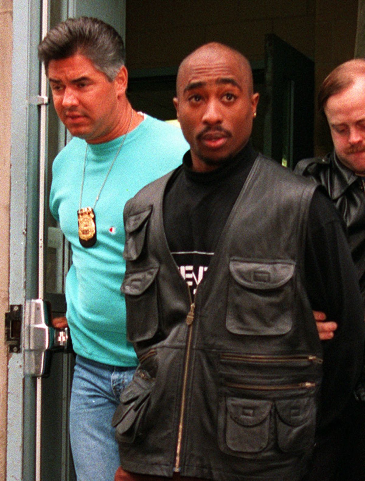 Rap star Tupac Shakur is led from the Manhattan North police precinct after being arrested in an alleged sexual attack on Nov. 19, 1993.  (AP Photo/Justin Sutcliffe) (Associated Press)