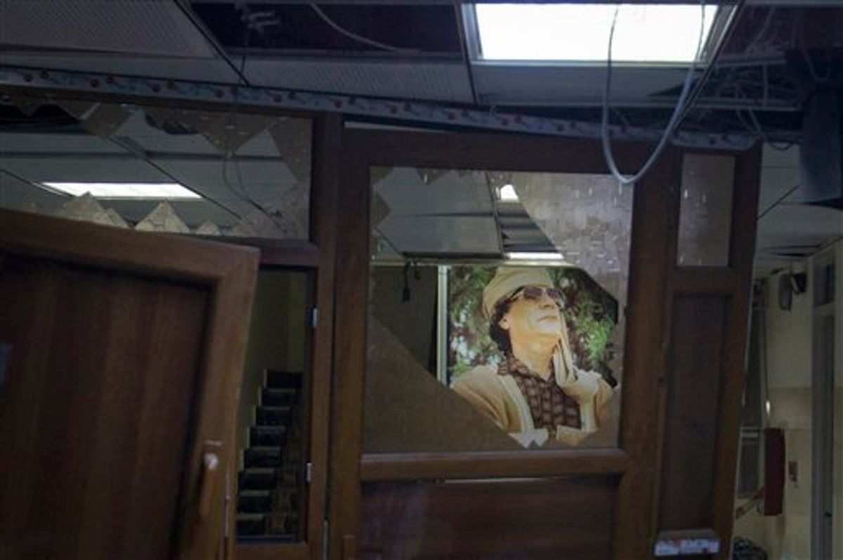 In this photo taken on a government organized tour, a poster of Libyan leader Moammar Gadhafi is seen in a damaged official building following an airstrike in Tripoli, Libya, early Tuesday, May 17, 2011. (AP Photo/Darko Bandic) (AP)